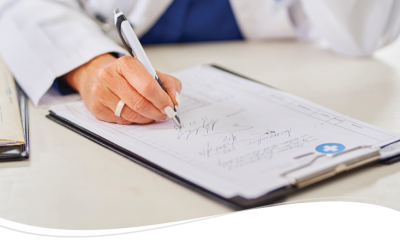 A medical professional writing on a clipboard