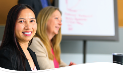 A business woman smiles while at a meeting